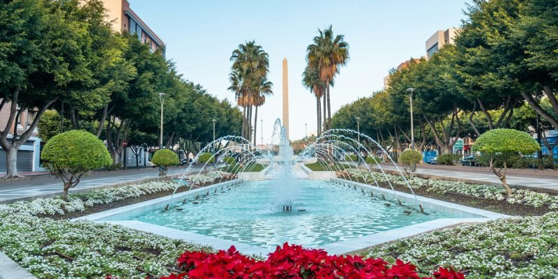 Water fountain and flowers next to the palm trees in the Belen of Almeria